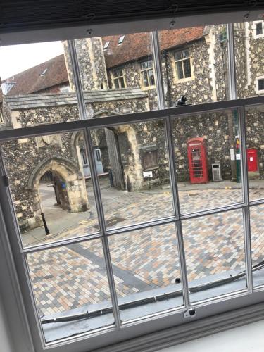 uma janela com vista para um edifício com uma cabina telefónica vermelha em The Borough apartment em Kent