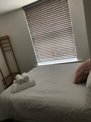 a bedroom with a bed with towels and a window at The Borough apartment in Kent