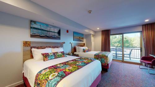 a hotel room with two beds and a balcony at Surfside On The Lake in Lake George