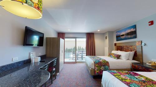 a hotel room with two beds and a balcony at Surfside On The Lake in Lake George