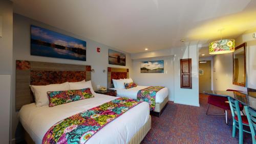 a hotel room with two beds and a desk at Surfside On The Lake in Lake George