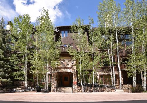 un antiguo edificio con árboles delante de él en Aspenwood Lodge #304 Condo, en Edwards