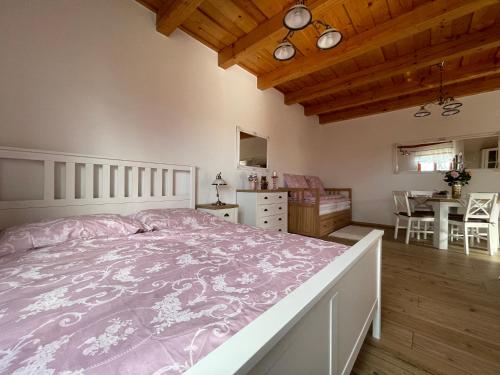 a bedroom with a large bed and a dining room at Rózsa Apartman Aggtelek in Aggtelek