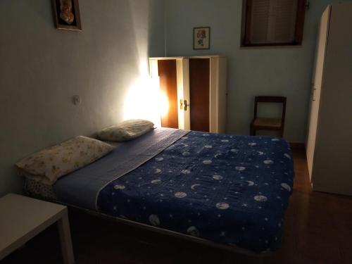 a bedroom with a bed with a blue comforter at Appartamento indipendente tra Amatrice e Leonessa in Favischio
