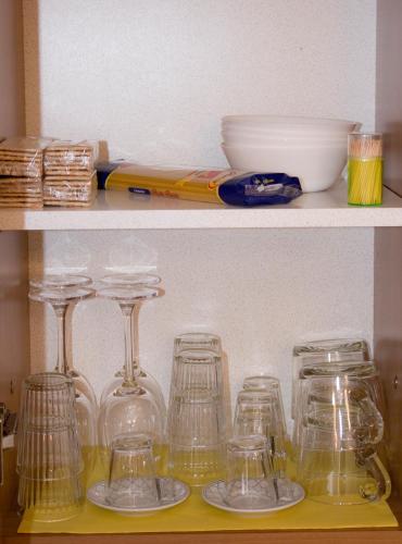 a shelf with several glass jars and a bowl at Appartamento incantevole con parcheggio gratuito in Tirano
