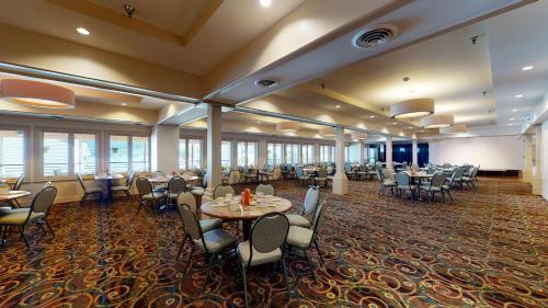 a restaurant with tables and chairs in a room at Surfside On The Lake in Lake George