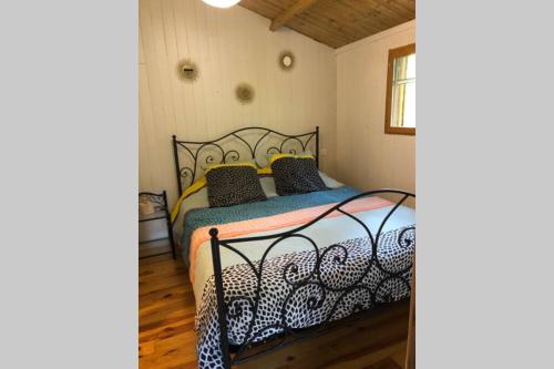 a bedroom with a bed with a black and white comforter at Ma petite cabane Gites des oliviers in La Roque-sur-Cèze