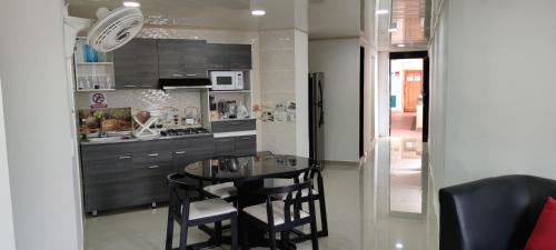 a kitchen with a table and chairs in a kitchen at Condominio al frente de la playa EL RODADERO! Amplio y hermoso apartamento in Santa Marta