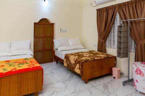 a bedroom with two beds and a window at Belljem Homes -your own private resort -4 BHK FF in Trichūr