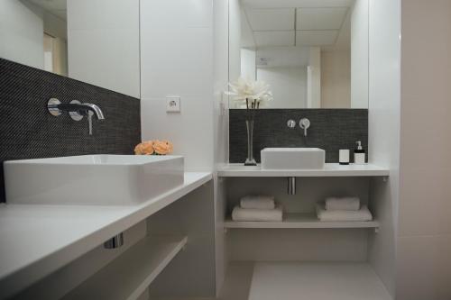 a white bathroom with a sink and a mirror at BN SUITES Rambla in Alicante