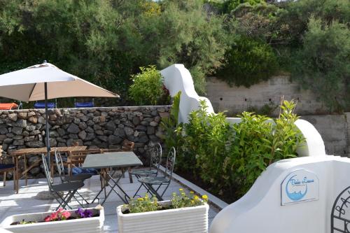 a patio with a table and chairs and an umbrella at Casa Baia Luna in Ponza