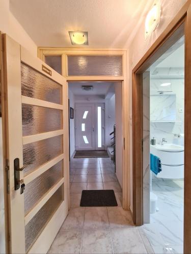 a hallway with a door leading to a bathroom at Apartment Garden in Slunj