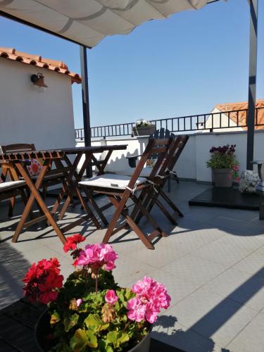 a patio with a table and chairs and flowers at Casa do Ti Messias in Almeida