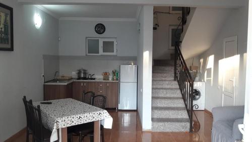 a kitchen and dining room with a table and a refrigerator at Apartment Ureki in Ureki