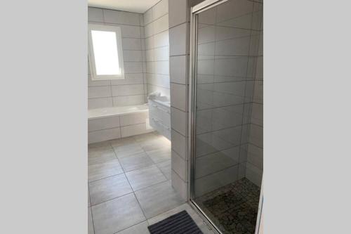 a shower with a glass door in a bathroom at Grande maison neuve idéale pour 6 personnes in Saint-Loubès