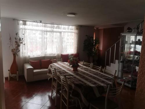 - un salon avec une grande table et un canapé dans l'établissement Hostal Turístico El Cajamarquez, à Lima