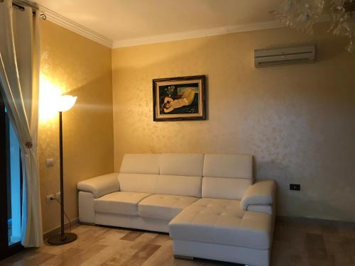 a living room with a white couch and a lamp at Villa Nuragica Sardegna in Bacu Abis
