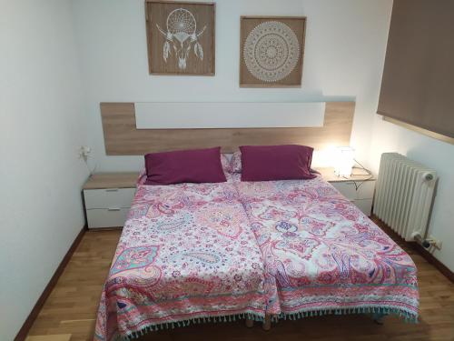 1 dormitorio con 1 cama grande con almohadas moradas en Apartamento Poniente con dos baños centrico, en Logroño