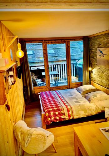 une chambre avec deux lits et un balcon dans l'établissement Le Gypaète, à Chamonix-Mont-Blanc
