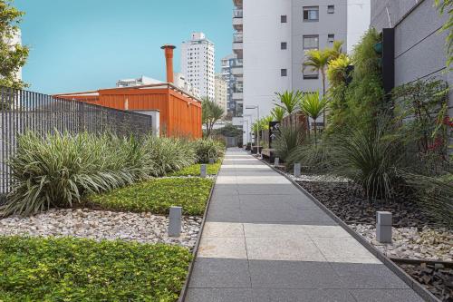 una acera en una ciudad con plantas y edificios en Vossa Bossa Vila Madalena en São Paulo