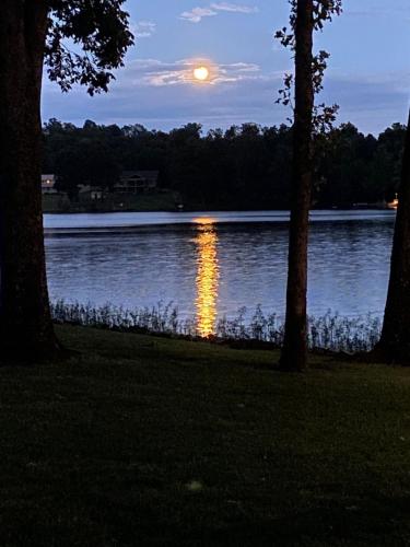 a full moon rising over a lake at dusk at Crown Lake Resort in Horseshoe Bend