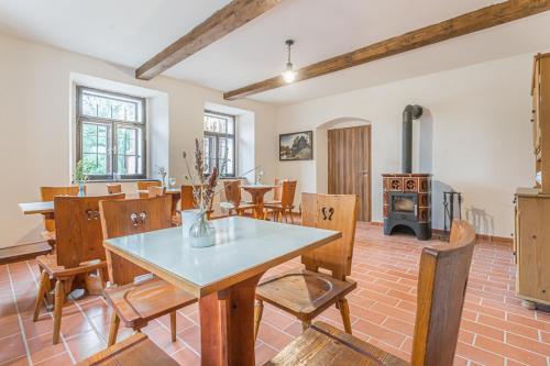 a living room with a table and chairs and a stove at Buškovský mlýn 1580 in Dolní Bousov
