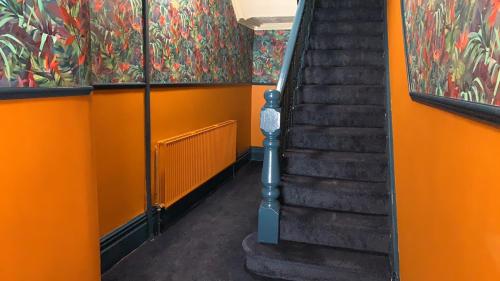 ブラックプールにあるTropics Beach Hotelの階段のあるオレンジ色の廊下
