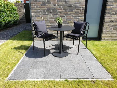 two chairs and a table in the grass at Studio Bourbon in Veere