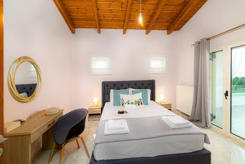 a bedroom with a bed and a desk and a mirror at Filema Luxury Villa in Hersonissos