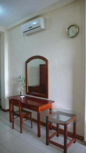 a room with a table and a mirror on the wall at Hotel Finlanka in Hikkaduwa