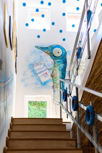 a painting of a bird on the wall of a staircase at Pensiunea Știuca Șchioapă in Băltenii de Sus