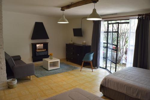 - une chambre avec un lit, une chaise et une cheminée dans l'établissement Finca del Pomar, à Acatlán
