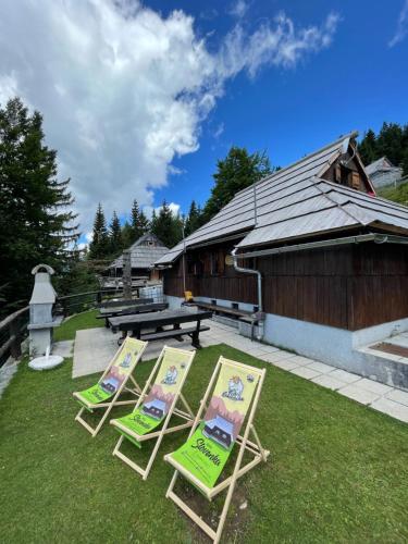 drie ligstoelen op het gras voor een gebouw bij Velika planina Chalet SLOVENKA in Stahovica