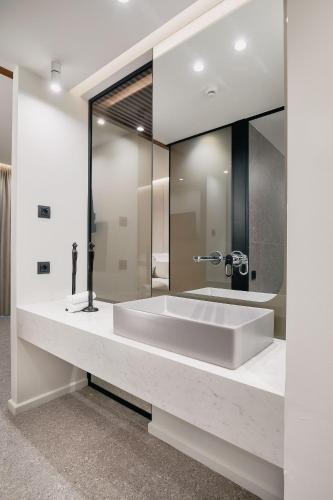 a large bathroom sink with a large mirror at Origami Boutique Residences in Nafplio