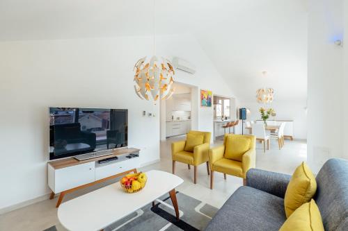 a living room with a couch and a tv at Apartments Villa Swissmonte in Herceg-Novi