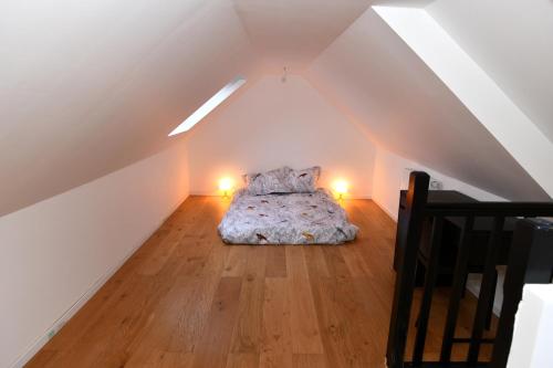 ein Schlafzimmer mit einem Bett im Dachgeschoss in der Unterkunft La maison penchée in Rosny-sous-Bois