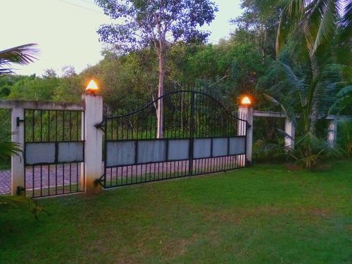 an iron gate with lights on it in a yard at Schatzi's Hideaway in Tangalle