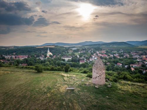 an old stone tower in a field with a city at Dorci Vendégház - A piece of peace in Cserépfalu