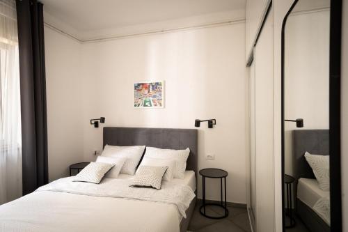 1 dormitorio con 1 cama con sábanas y almohadas blancas en Amalis, en Rijeka