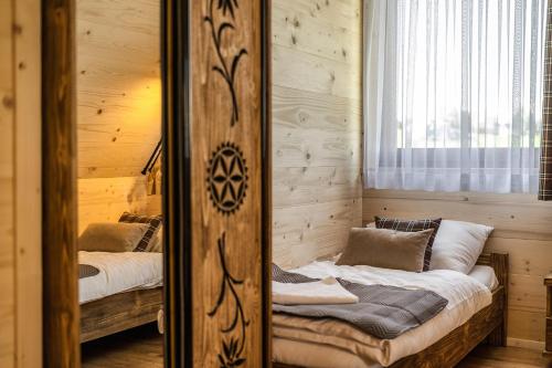 a bedroom with two beds and a mirror at Osada Wierchlove Domki in Bustryk