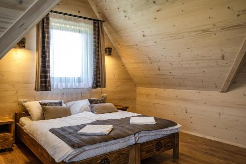 a bedroom with a bed in a log cabin at Osada Wierchlove Domki in Bustryk