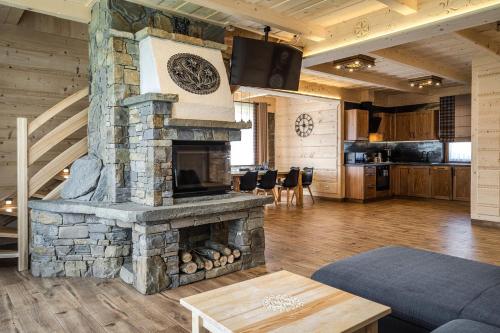 a large living room with a stone fireplace at Osada Wierchlove Domki in Bustryk