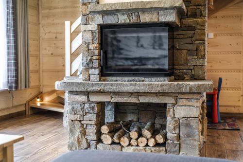 a stone fireplace with a tv on top of it at Osada Wierchlove Domki in Bustryk