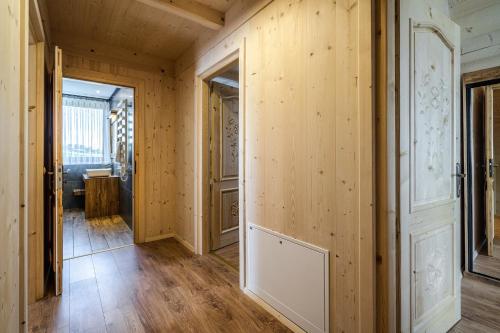 a hallway with wood paneled walls and a door at Osada Wierchlove Domki in Bustryk