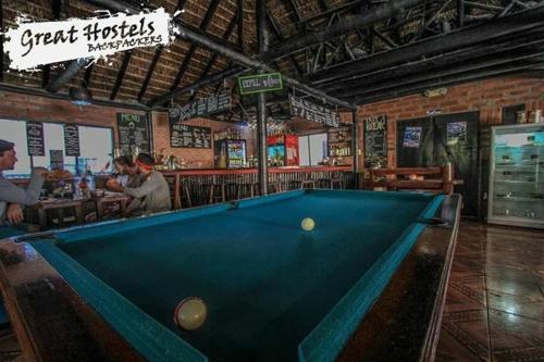 a large room with a bar and a large wooden table at Great Hostels in Baños