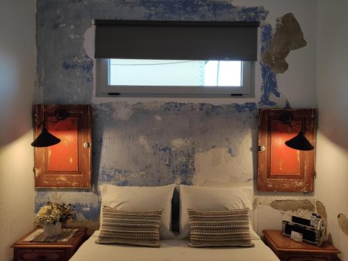 a bedroom with a bed with a window and two mirrors at Be My Neighbour in Lisbon