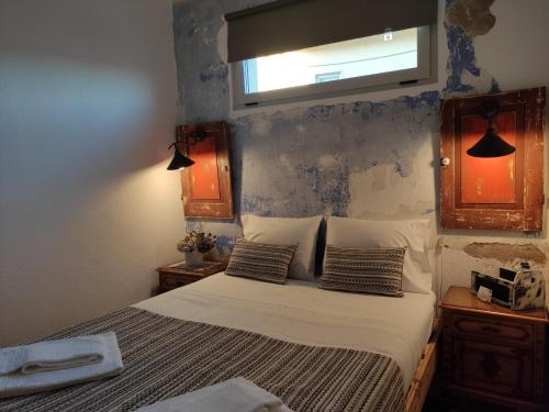 a bedroom with a bed with two pillows and a window at Be My Neighbour in Lisbon