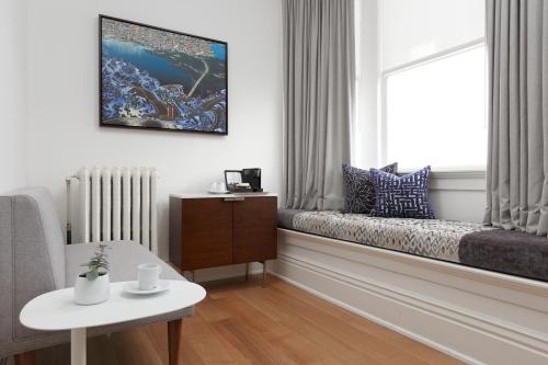a living room with a window seat and a table at Victorian Hotel in Vancouver
