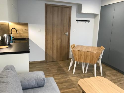 a living room with a table and a kitchen at Apartament Łąki18 in Wadowice
