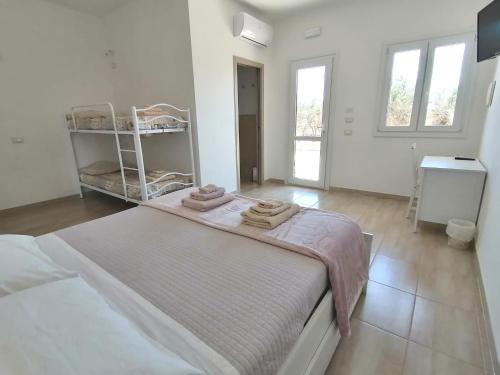 a white room with a bed with towels on it at Piccolo Ulivo B&B Salento in Vernole